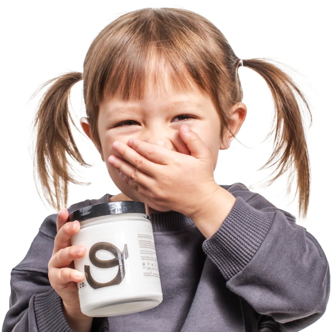 Little girl holding every day body butter by original co holding her hand over mouth.